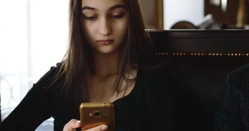 Woman holding smartphone with concerned expression