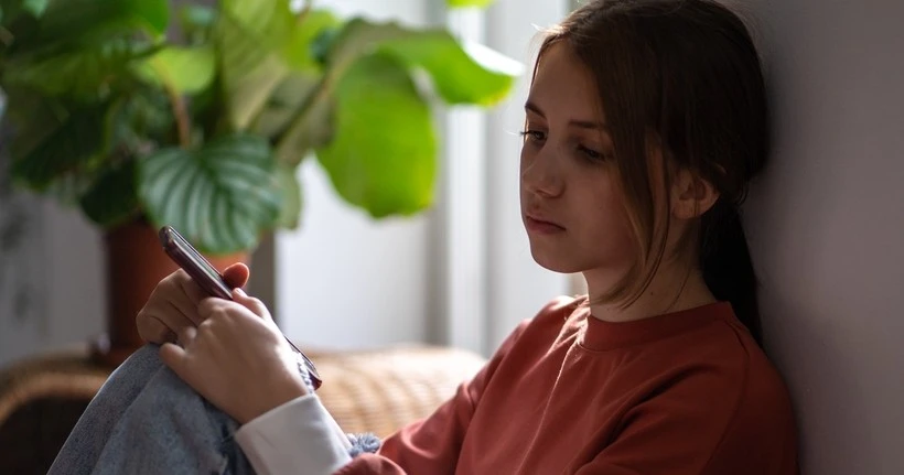 Girl using smartphone in bedroom