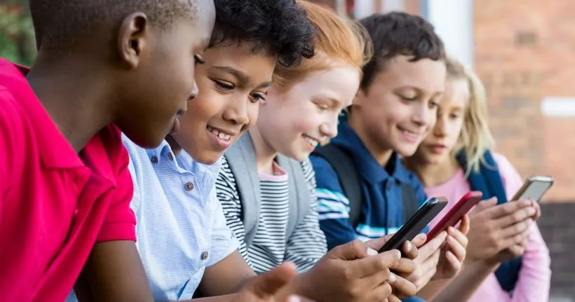 Kids viewing smartphones in group