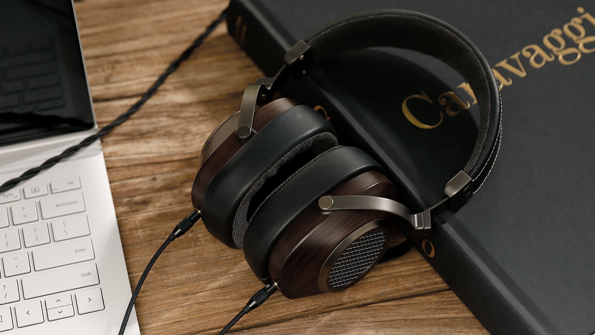 Wooden headphones resting on dark book