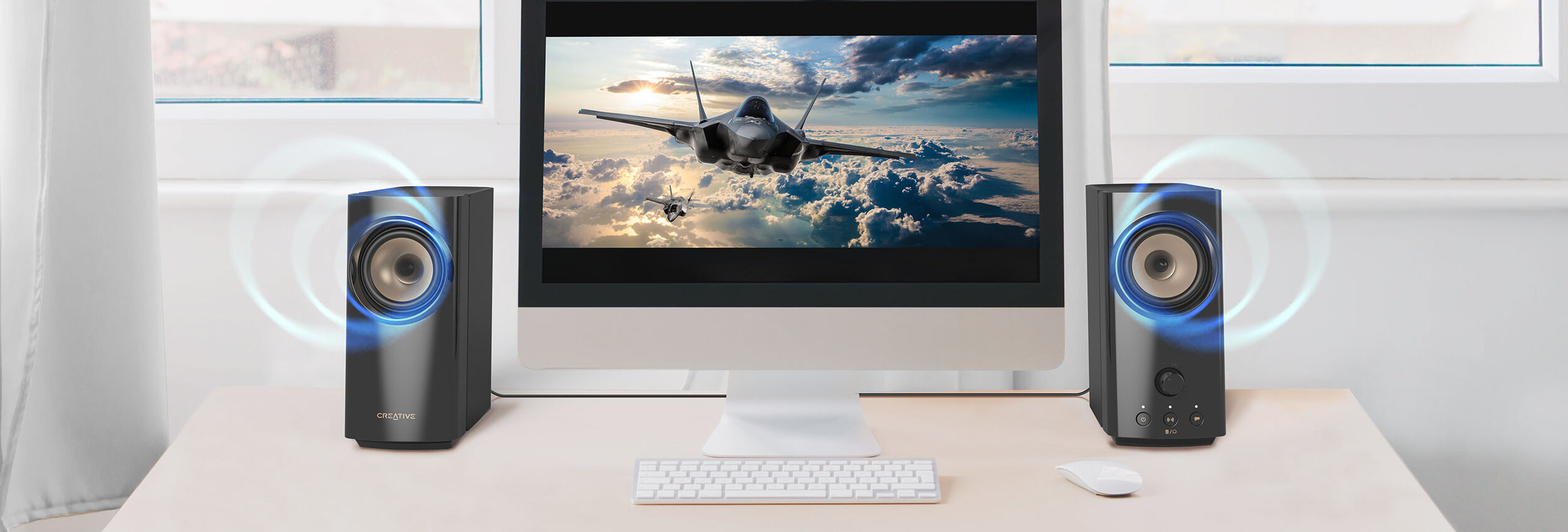 Two white desktop speakers on workspace