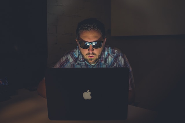 Man using laptop in dimly lit room