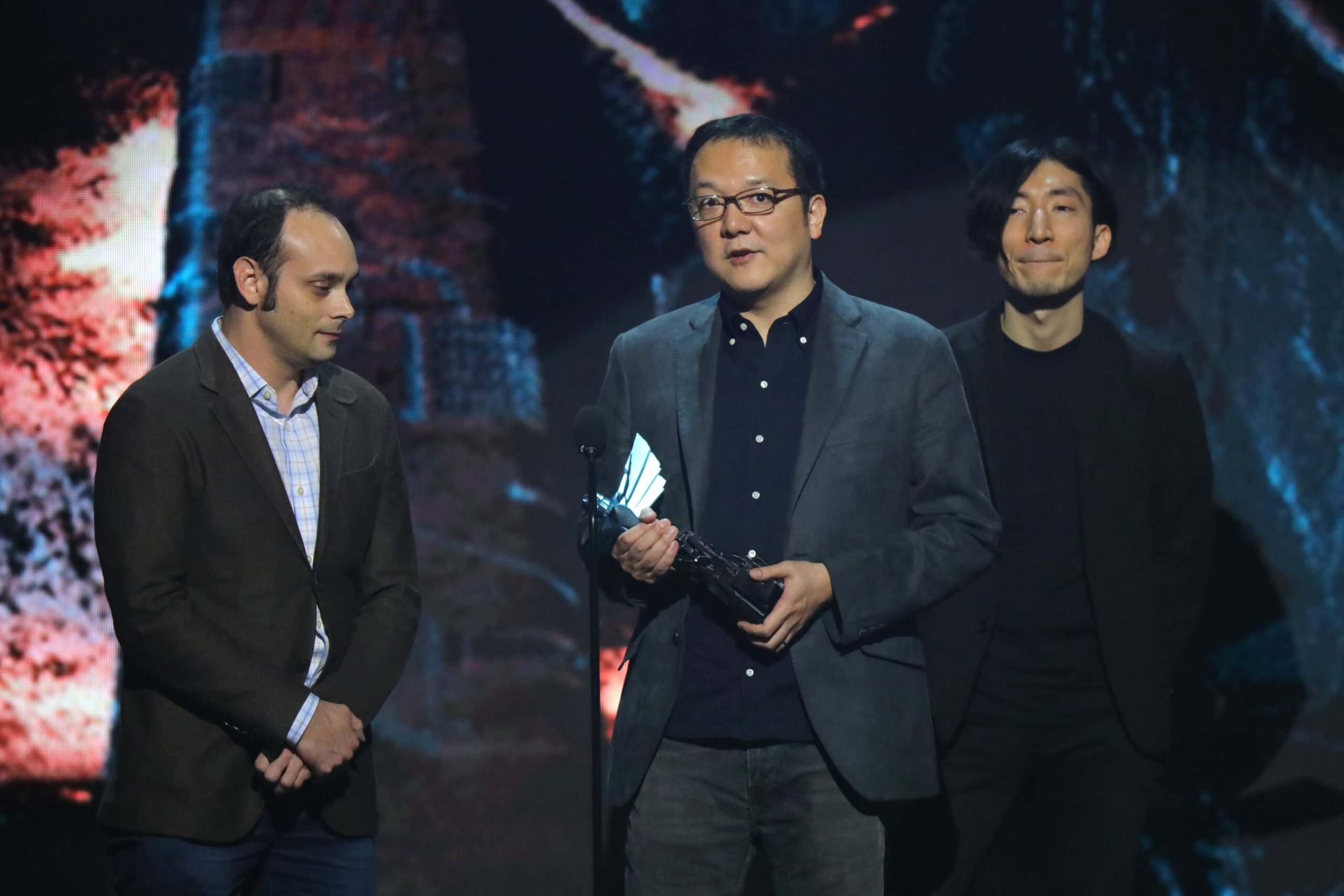 Miyazaki holding award trophy